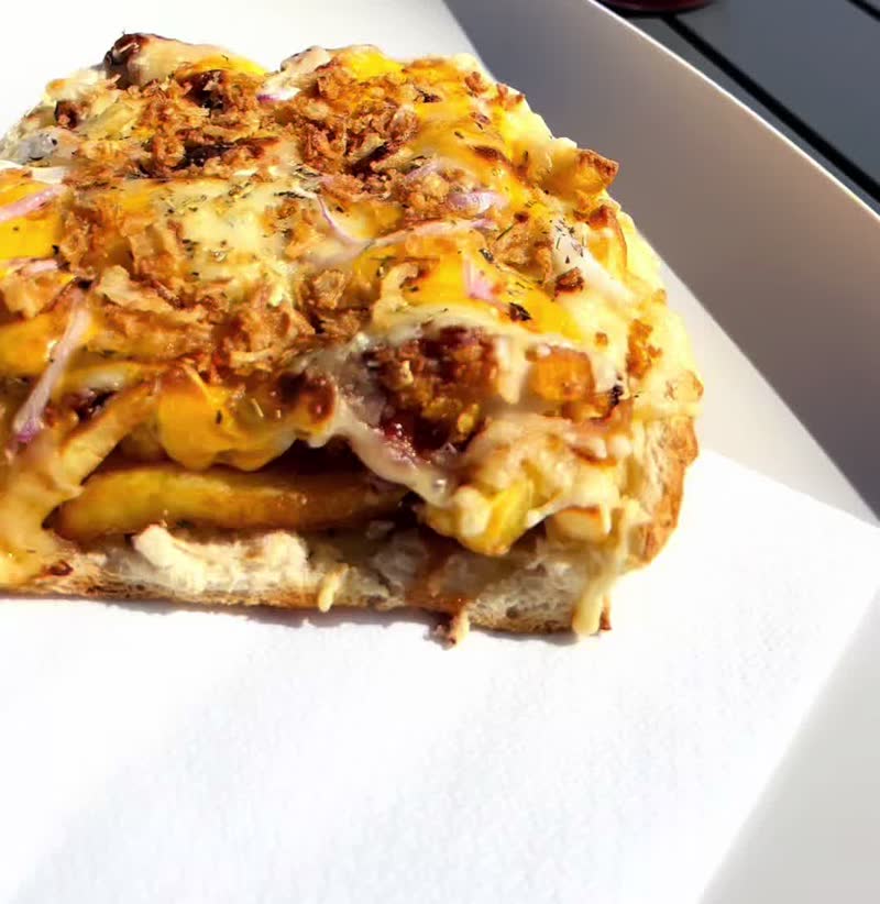 Mini Texan gratiné sur une assiette blanche, en terrasse